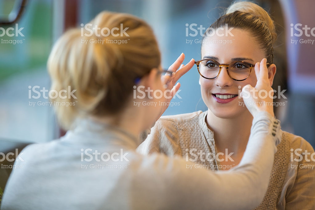 Photo of woman fitting a girl with glasses
